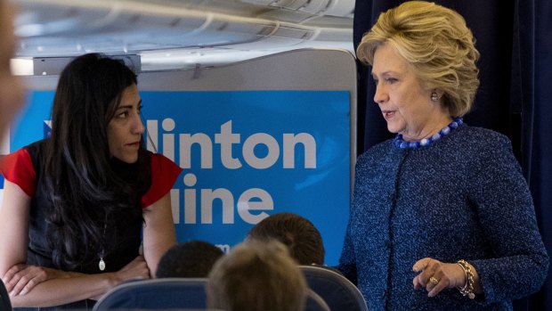Hillary Clinton speaks with Huma Abedin aboard her campaign plane to Iowa on Friday.