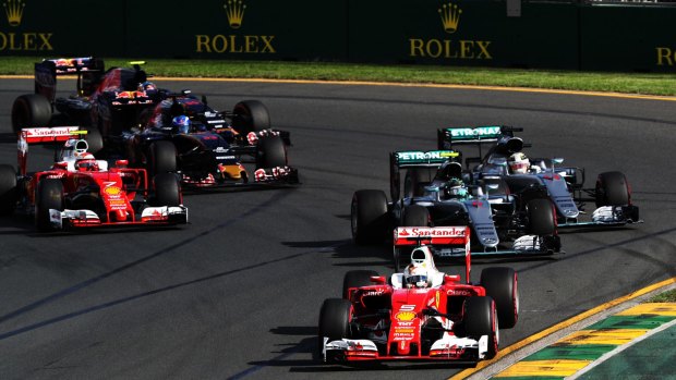 Sebastian Vettel squeezes through the McLaren front row to take the lead.
