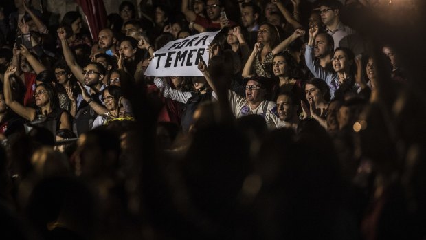 Supporters of Dilma Rousseff, suspended president of Brazil, cheer and hold a sign against Michel Temer in Rio de Janeiro.