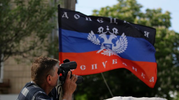 A pro-Russian rebel looks through binoculars at a rebel position in Slavyansk in eastern Ukraine, May 2014.