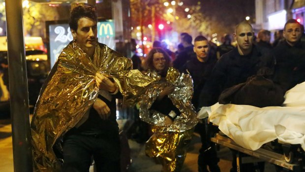 Victims of a mass shooting walk away outside the Bataclan theatre.