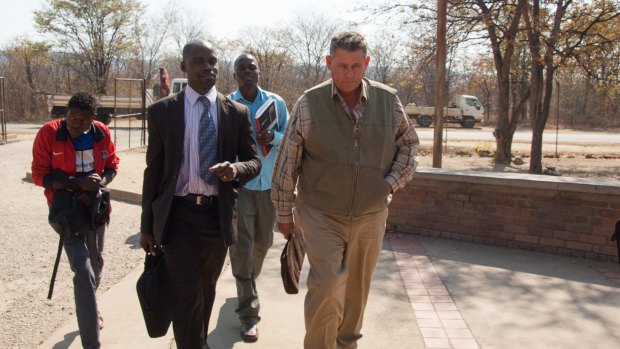 Theo Bronkhorst, right, a professional hunter, arrives for his appearance at the magistrates courts in Hwange, Zimbabwe, in July 2015.