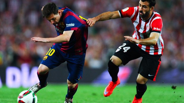 No holding him back:  Lionel Messi of FC Barcelona competes for the ball with Mikel Balenziaga.