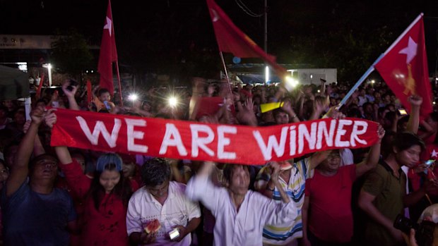 Hopeful supporters of Aung San Suu Kyi's National League for Democracy party anticipate the result of general election outside the party's headquarters on Sunday.