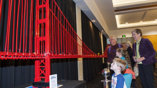 Jasper Pellart, 5, and sister Hollie, 7, of Evatt, admire the Lego Golden Gate Bridge with grandparents Phil and Helen Pellart. 
