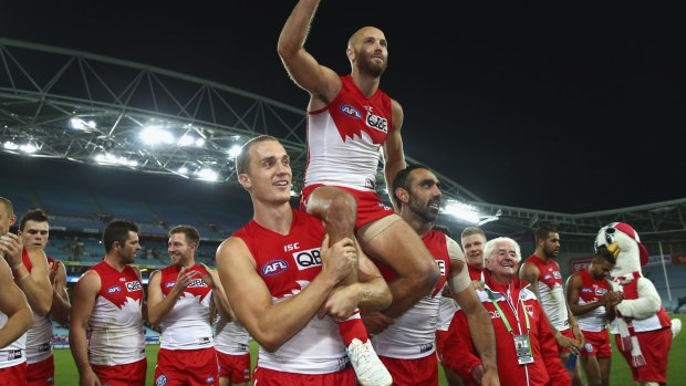 Jarrad McVeigh of the Swans is chaired from the ground.