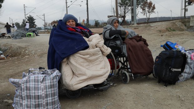Two women in wheelchairs wait for the border to Macedonia to open.