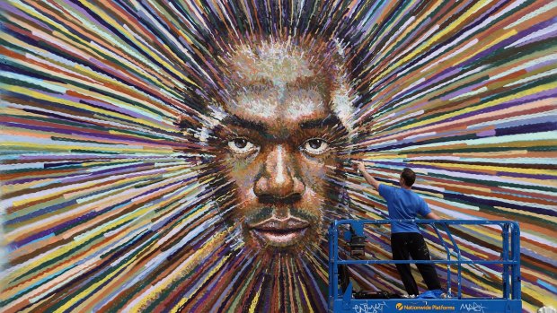Street artist Jimmy C puts the finishing touches to a piece of work depicting the face of Usain Bolt in London.