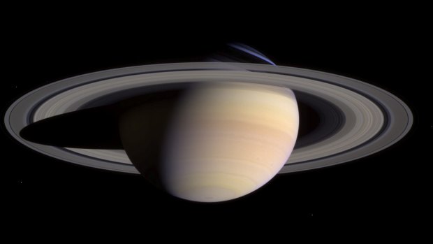 This composite of two images, taken by the Cassini spacecraft, shows a wide view of Saturn. The white dots in the image are some of Saturn's moons. 