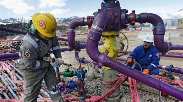 Workers tend to a well head during a hydraulic fracturing operation outside Rifle, Colorado. 