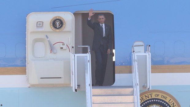 US President Barack Obama waves as he exits Air Force One.