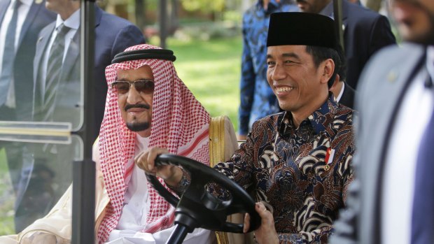 Saudi King Salman, left, rides on a golf cart with Indonesian President Joko Widodo.