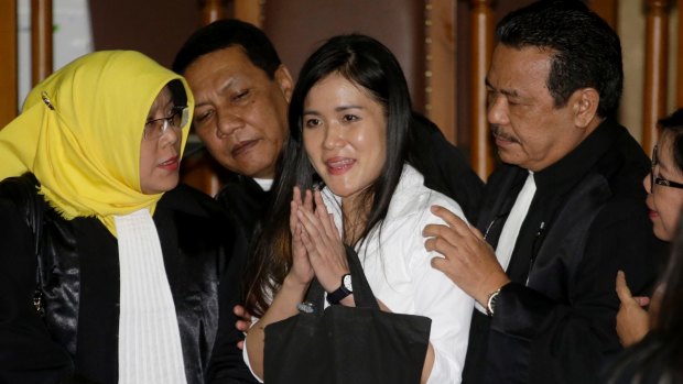 Jessica Kumala Wongso, centre, flashes a smile as she is surrounded by her lawyers after her jail sentence at a courtroom of Central Jakarta District Court. 