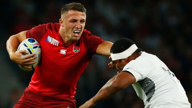 Cross-coder: Sam Burgess hands off Tuapati Talemaitoga of Fiji during the World Cup.
