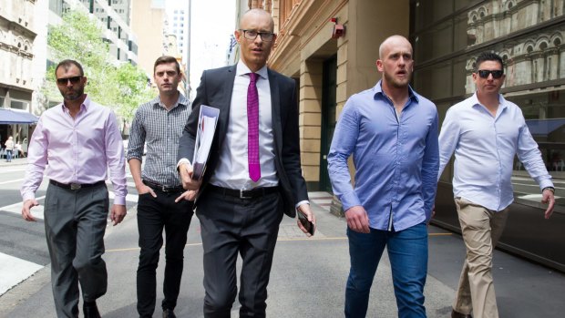 Shane Housego, Christian McDonald, Chris Sheehy and Steven Rapisarda join lawyer Nicholas Stewart (centre) to lodge papers at the NSW Civil and Administrative Tribunal in Sydney. 