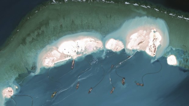 A handout satellite image shows dredgers working at the northernmost reclamation site of Mischief Reef, part of the Spratly Islands, in the South China Sea, in February.
