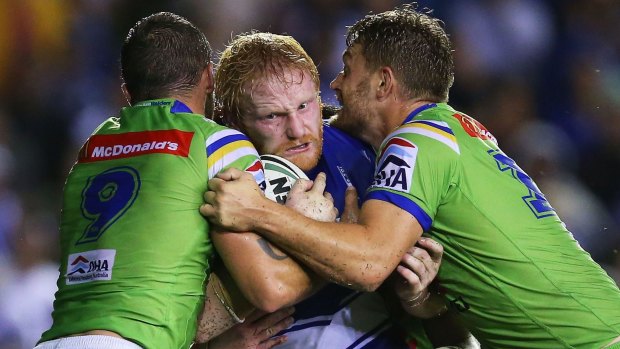 The Canberra Raiders muscle up in defence against Canterbury's James Graham at Belmore on Monday night.