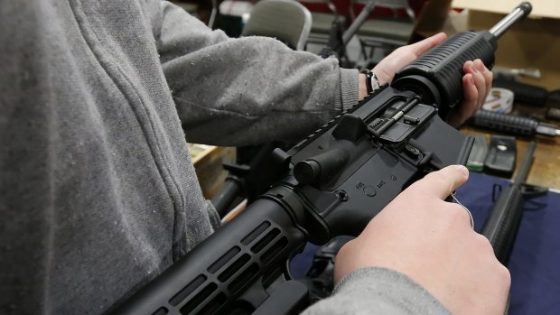 A man holds a semi-automatic assault rifle at the Rocky Mountain Gun Show in Sandy, Utah.