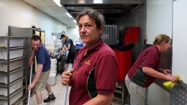 Yatala Pie's manager Heather Gay puts on a brave face with staff during flood clean up efforts on April 1. She said help had not been hard to find with many locals, including past staff, stepping up. 