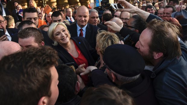 People surround National Front leader Marine Le Pen and cheer during her rally.