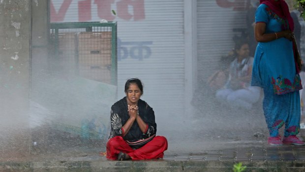 A Dera Sacha Sauda sect supporter braves water cannon used by Indian security forces to disperse violent supporters near a court in Panchkula.