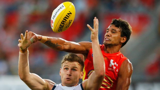 Small win: Callum Ah Chee of the Suns tries to punch the ball clear of Adelaide's Rory Laird.