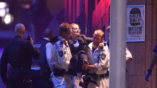A hostage is carried out of Martin Place to a waiting ambulance in the early hours of Tuesday morning. 