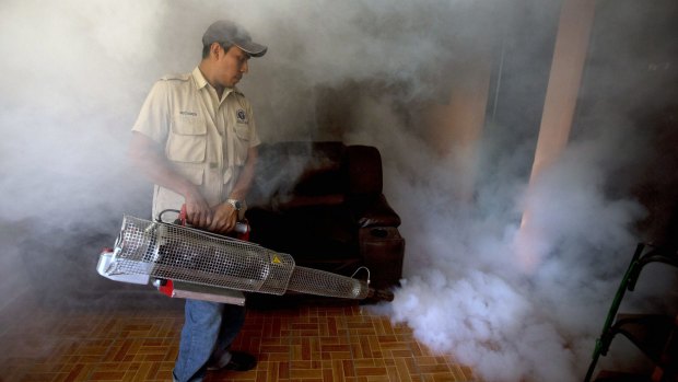 A worker from the Ministry of Health sprays insecticide inside a home to eradicate the mosquitoes responsible for spreading the Zika virus in Guatemala City.