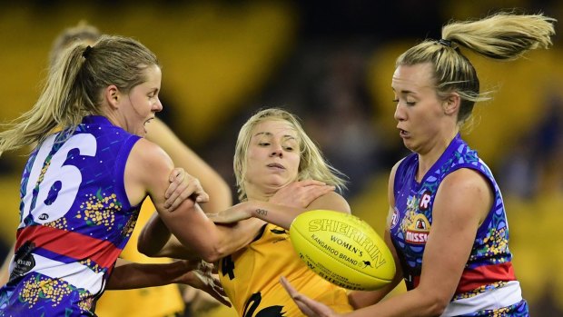 WA's Demi Okely is tackled by Bulldogs Katie Brennan and Lauren Arnell during an exhibition match