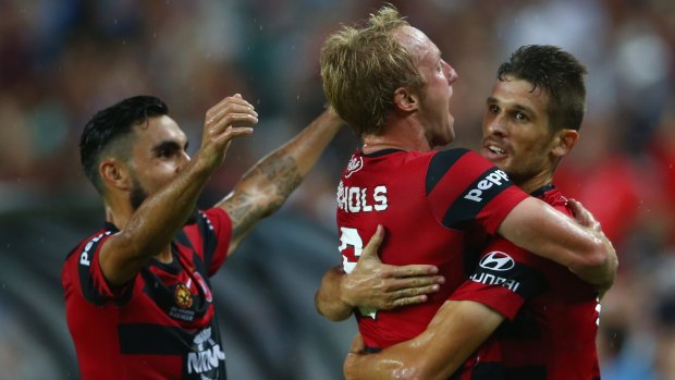Derby delight: Wanderers players Dimas and Mitch Nichols celebrate Dario Vidosic's (right) goal in the derby.