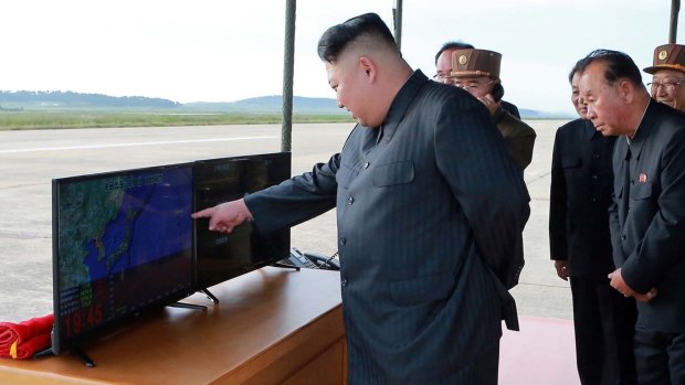 Kim Jong-un, centre, attends what was said to be the test launch of an intermediate range Hwasong-12 missile on Friday.
