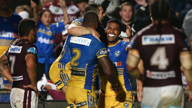 Double celebration: Michael Jennings of the Eels is mobbed by teammates after scoring.