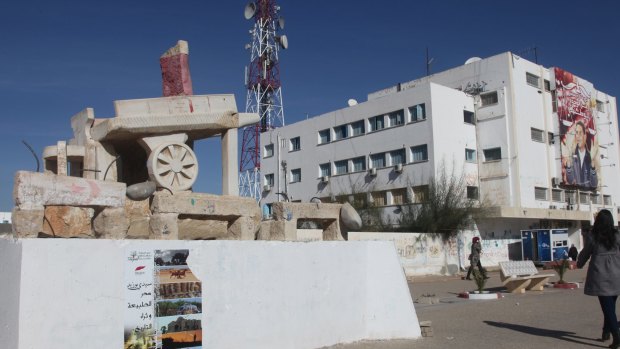 Within sight of the giant poster, a stone fruit and vegetable cart commemorates Mohamed Bouazizi.