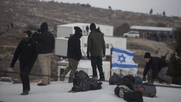 Settlers stand on the roofs of the Amona outpost, where 330 settlers have made their homes in defiance of Israeli and international law.