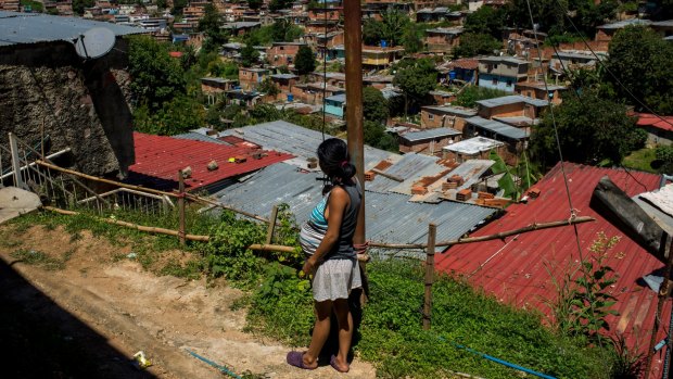 Yusdelis, 19 years old and eight months pregnant, stands near her house in a slum area of Los Teques, in Miranda state, outside Caracas.