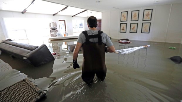 Gaston Kirby walks through floodwater inside his home in the aftermath of Hurricane Harvey in Houston. 