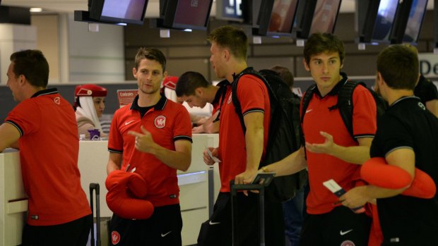 Protest? Western Sydney Wanderers team members wait for their boarding passes at the counter before their departure for Saudi Arabia. 