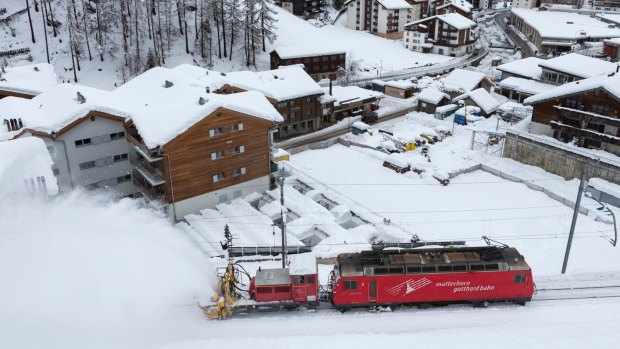 A snow blower on a train clears snow from the rail track in Zermatt, Switzerland.
