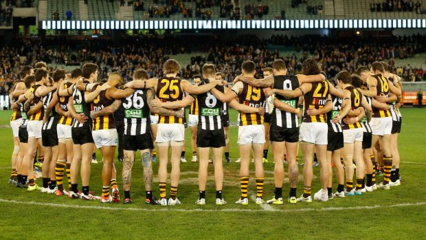 Hawthorn and Collingwood players form a circle in remembrance of slain Adelaide coach Phil Walsh after the round 14 match at the MCG on Friday night.