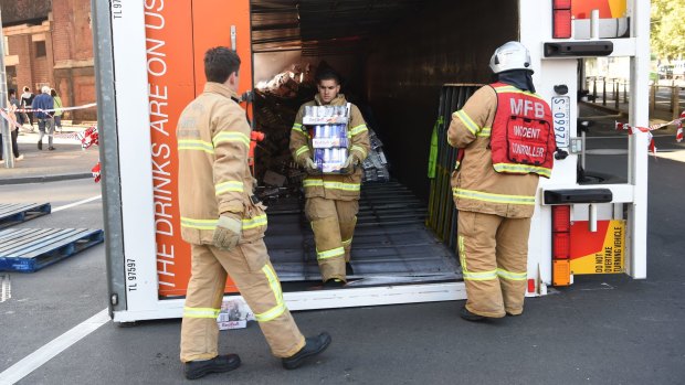Firemen remove pallets of Red Bull from the truck.
