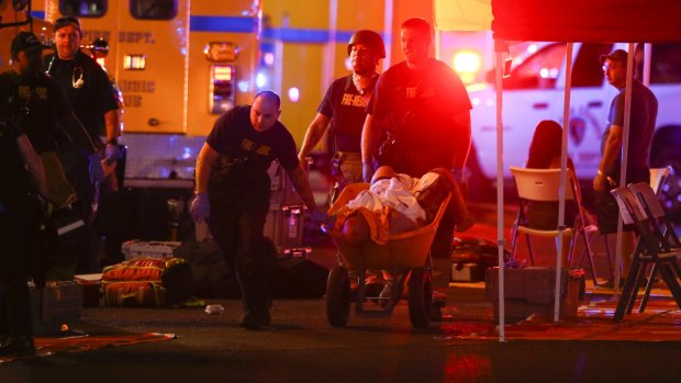 A wounded person is walked in on a wheelbarrow as Las Vegas police respond during the shooting.