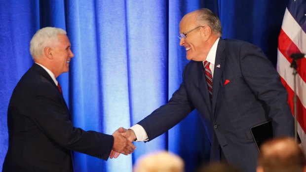 Republican vice presidential candidate Mike Pence, left, shakes hands with former New York mayor Rudy Giuliani, before Donald Trump spoke in Youngstown, Ohio.