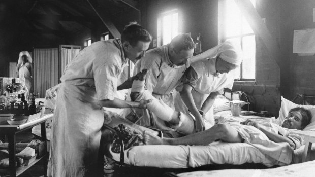 Medical staff apply a dressing to the leg of a wounded World War I French soldier at a mobile hospital south-west of Amiens. 