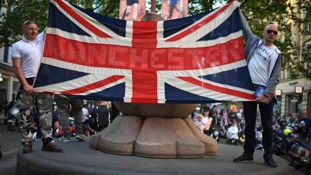 Scooter enthusiasts hold up a Union Jack flag as they arrive at St Ann's square to pay tribute to Olivia Campbell, who died in Monday's terror attack.