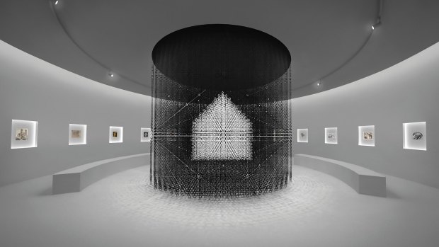 An impression of the nendo 'chandelier' of 30,000 tiny houses surrounded by Escher prints. 