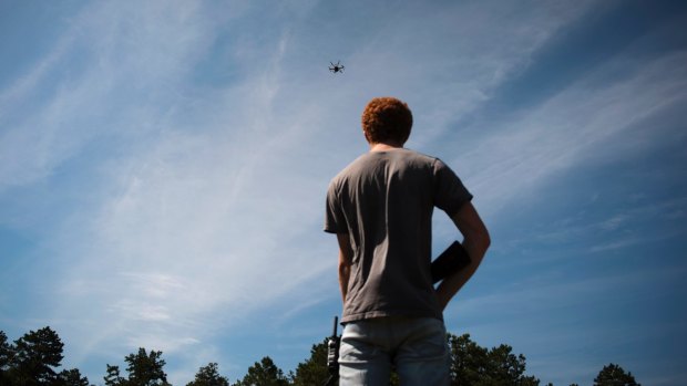 Jacob Regenstein, an engineer, holds a fake rifle while testing an airborne autonomous drone.