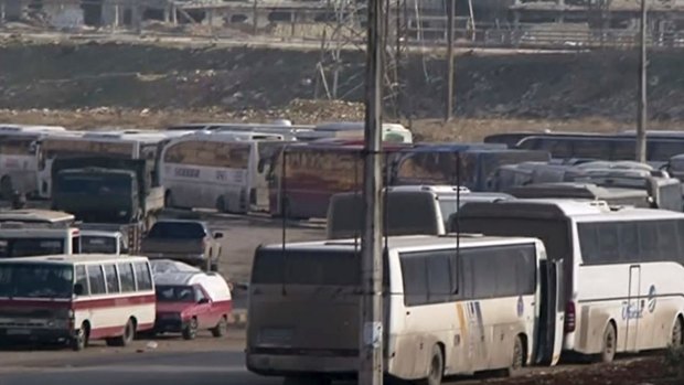 In this still image taken from Syrian TV, buses line up to cross into east Aleppo on Sunday.