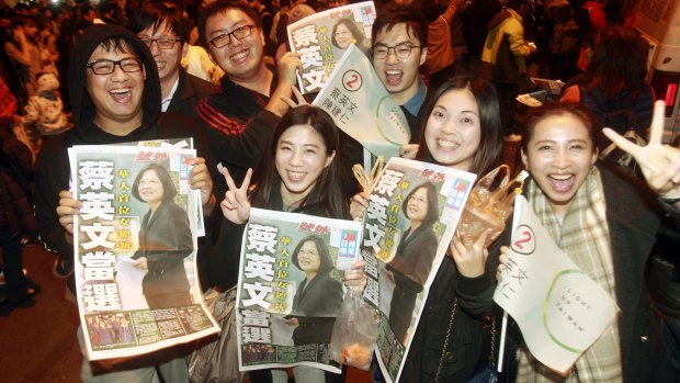 Supporters of the Democratic Progressive Party's Tsai Ing-wen display newspaper headlines featuring the newly elected president.