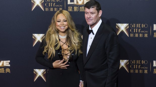 James Packer, co-chairman of Melco Crown Entertainment Ltd., right, and singer Mariah Carey stand for photographs at a red carpet event. 