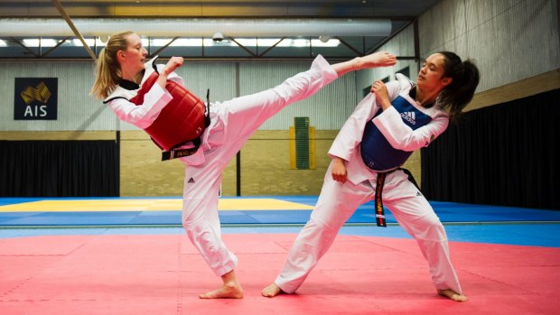 Getting their kicks: Canberra taekwondo exponents Keshena Waterford (red) and Catherine Risbey (blue).
